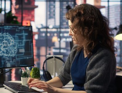 Femme travaillant sur son ordinateur avec un logiciel de gestion, illustrant l'usage d'un CRM/ERP au bureau